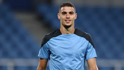 Mid-30s athletic forward, muscular build, waist-up, wearing a plain sky-blue and black training shirt (smooth polyester...