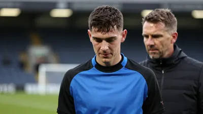 A close medium shot fills the frame with a young Dundee United defender, circa 20 years old, athletic build, focused...