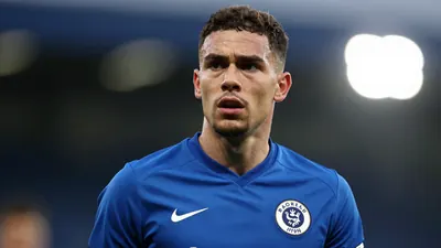 A close-up of a 27-year-old Derby County defender's face, looking concerned, with his kit a clean, smooth, blue fabric