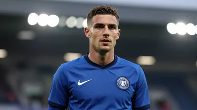A focused shot of a Championship midfielder in a blue kit, waist-up