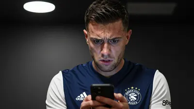 A close-up shot of a Derby County staff member, wearing a navy blue jersey with white sleeves, looking frustrated and...